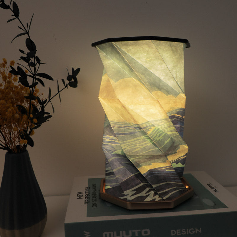 Lampe en papier pliable de style chinois allumée sur une table de chevet, créant une ambiance zen.